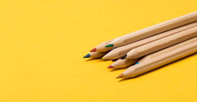 Colourful pencils over a yellow background